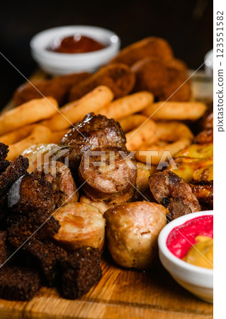 Assorted grilled meat appetizers on wooden board, top view. 123551582