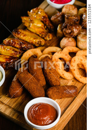 Assorted grilled meat appetizers on wooden board, top view. 123551584