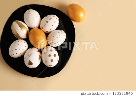 Decorated golden Easter eggs on a yellow background. Minimal holiday concept. Happy Easter background with copy space, place for text. Creative painting of eggs at home. Decorated golden Easter eggs on a yellow background. Minimal holiday concept. Happy Easter background with copy space, place for text. Creative painting of eggs at home. 123551940