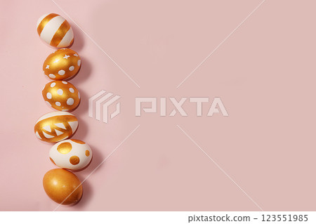 Decorated golden easter eggs on a pink background. Minimal holiday concept. Happy easter background. Creative painting of eggs at home. Decorated golden easter eggs on a pink background. Minimal holiday concept. Happy easter background. Creative painting of eggs at home. 123551985