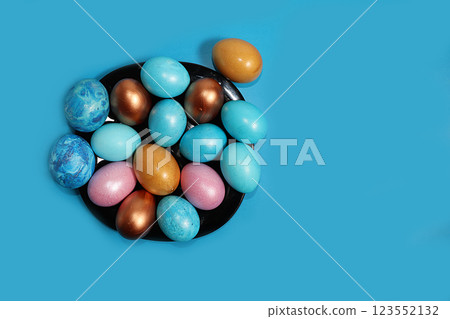 Decorated golden and blue easter eggs on a dark blue background. Minimal holiday concept. Happy easter background. Creative painting of eggs at home, the idea of simple drawings for coloring, a place 123552132