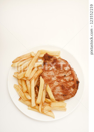 Roast pork loin with fried potatoes. Delicious meat breakfast. French fries. 123552159