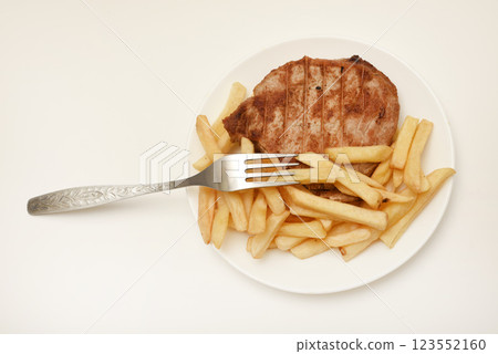 Roast pork loin with fried potatoes. Delicious meat breakfast. French fries. 123552160