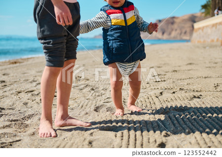 Children Enjoying a Summer Day on a Sandy Beach by the Ocean 123552442