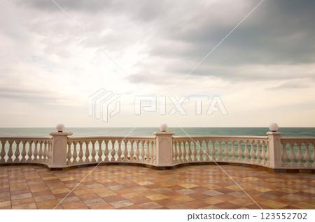 Terrace by the sea with railings and columns against a dramatic sky. A sad and lonely mood. 123552702