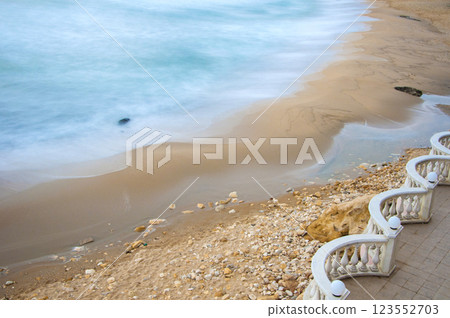 Terrace by the sea with railings and columns against a dramatic sky. A sad and lonely mood. 123552703