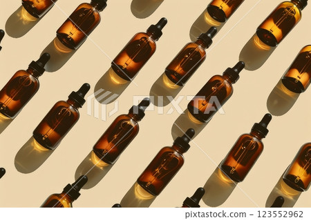 Brown glass dropper bottles are neatly arranged in a captivating pattern on a light surface, showcasing their elegant design and shadows 123552962