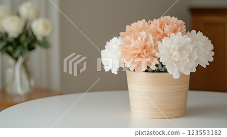 A beautiful arrangement of pink and white carnations in a wicker basket set against a soft grey background, perfect for greeting cards 123553182