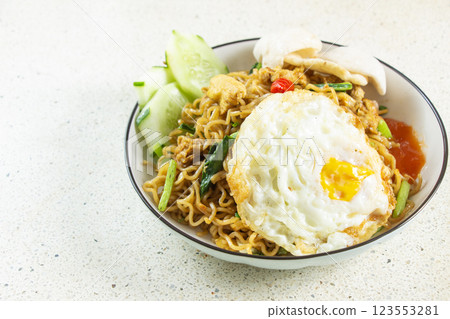 Fried mei with round egg topping, cucumber slices, sauce, white marble texture table background, indonesian food Fried mei with round egg topping, cucumber slices, sauce, white marble texture table background, indonesian food 123553281