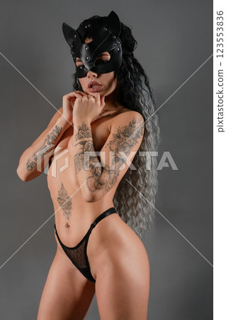 Sensual woman in lingerie with tattoos posing in a dramatic setting Sensual woman in lingerie with tattoos posing in a dramatic setting 123553836