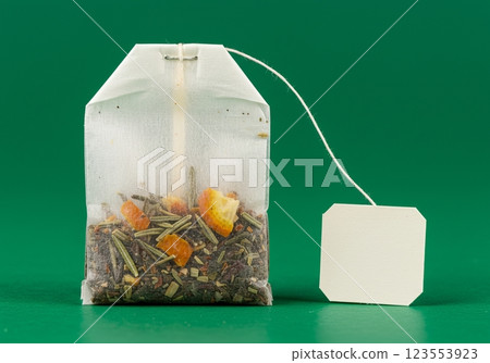 Herbal tea bag with citrus and herbs on green background 123553923