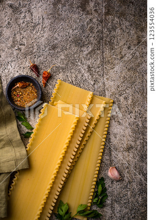 Uncooked lasagna pasta with cooking ingredient Uncooked lasagna pasta with cooking ingredient 123554036