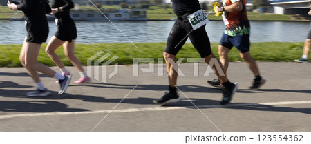 Motion blurred marathon runners in a city. Group of marathon runners compete in the race outdoors Motion blurred marathon runners in a city. Group of marathon runners compete in the race outdoors 123554362