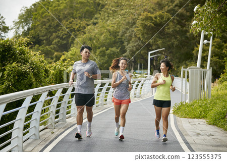 young asian adults running jogging outdoors 123555375