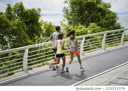 three young asian people running jogging outdoors 123555376