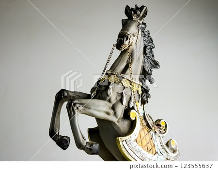 Statuette of a horse in multi-colored harness. The horse is rearing. Close-up. 123555637