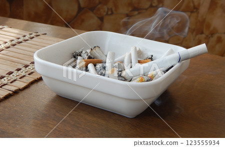 Extinguished filter cigarette butts and ashes in ashtray Extinguished filter cigarette butts and ashes in ashtray 123555934