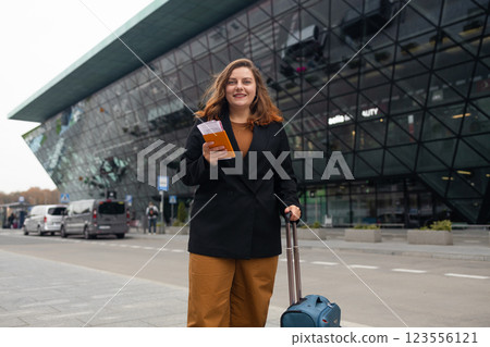 Smiling 30s lady tourist woman in casual clothing with smart phone taking taxi from an airport. Luggage on the city street. Travel concept. Smiling 30s lady tourist woman in casual clothing with smart phone taking taxi from an airport. Luggage on the city street. Travel concept. 123556121