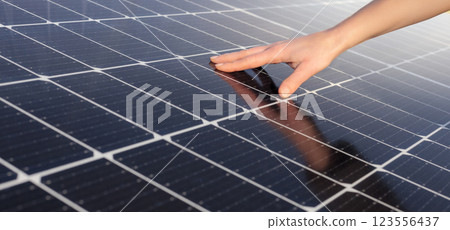Close up of a hand touching a solar panel surface, symbolizing renewable energy, sustainability, and solar power technology. Close up of a hand touching a solar panel surface, symbolizing renewable energy, sustainability, and solar power technology. 123556437