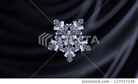 Snowflake rotating on black silk background 123557236