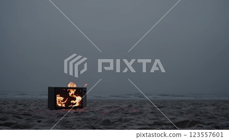 Burning Television Set on a Deserted Beach at Dusk 123557601