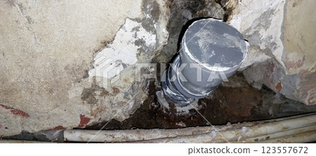 Plumber Installs a New Plumbing Pipe in a Residential Construction Site During Early Morning Hours Plumber Installs a New Plumbing Pipe in a Residential Construction Site During Early Morning Hours 123557672