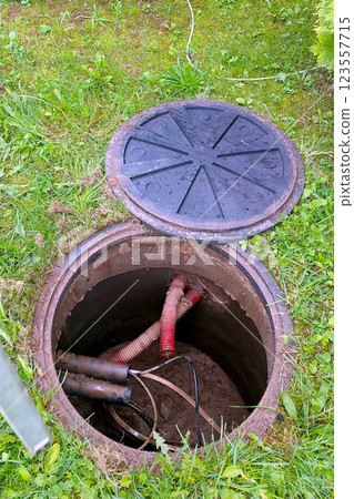 Exposed Well Cables and Maintenance Access in a Grassy Area During Daylight Hours Exposed Well Cables and Maintenance Access in a Grassy Area During Daylight Hours 123557715