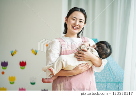 A young woman working as a nursery teacher for infants A young woman working as a nursery teacher for infants 123558117
