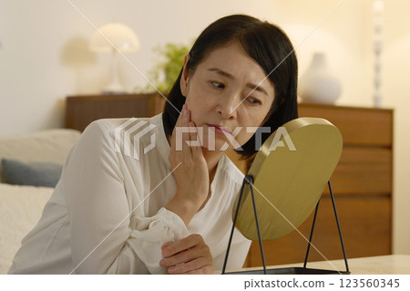 一位 50 多歲的女性患有皮膚問題，晚上在客廳 123560345