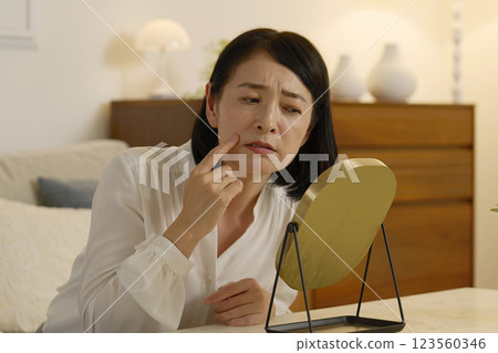 一名 50 多歲的女性患有法令紋，晚上在客廳 123560346