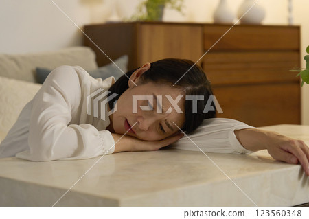 Tired woman in her 50s in the living room at night 123560348