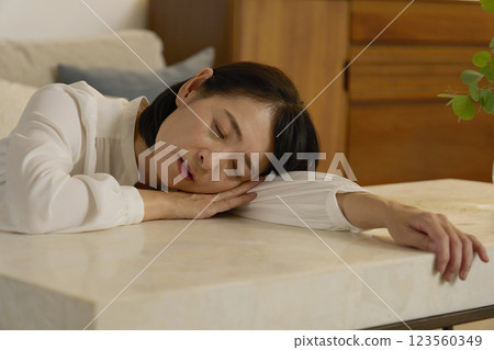 A tired woman in her 50s sleeping in the living room at night A tired woman in her 50s sleeping in the living room at night 123560349