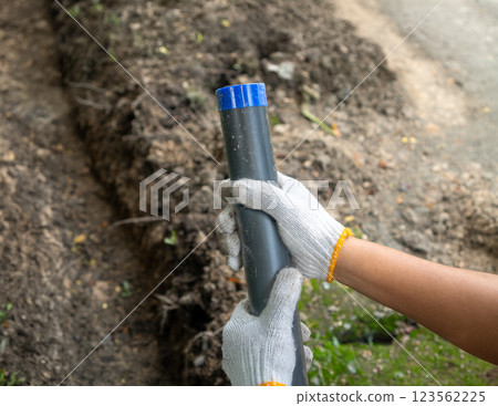 Pipe contractor install new HDPE pipes under the ground in village, 123562225