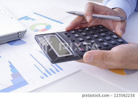 A man doing business calculations on a calculator 123562238