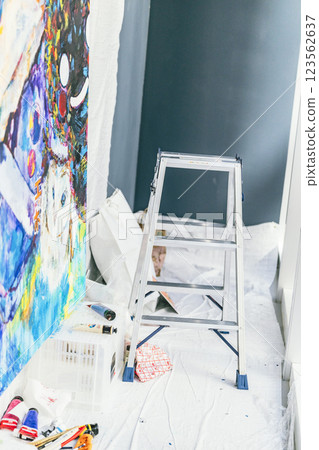 A protected floor, live painting production site, step ladder and paints 123562637