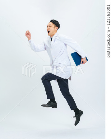 身穿白大褂的中年男性醫生/研究員跳躍的全身照片 123563001
