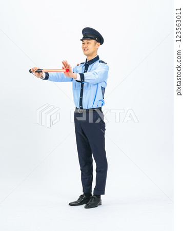Full-body photo of a middle-aged male security guard directing traffic 123563011