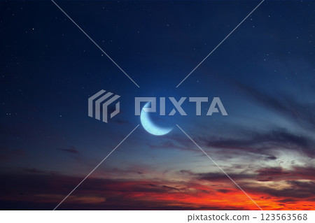 Islamic night sunset with a view of the crescent moon. Hilal and Eid at night with some clouds in the sky. Copy space or mockup. Concept of Eid Al Fitr and Ramadan Mubarak. Ramadan background 123563568