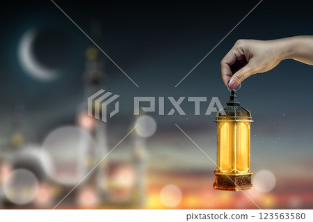 Muslim man holding traditional glowing Arabic lantern with blurred of mosque with crescent moon. Copy space or mockup. Concept of Eid Al Fitr and Ramadan Mubarak. Ramadan kareem background Muslim man holding traditional glowing Arabic lantern with blurred of mosque with crescent moon. Copy space or mockup. Concept of Eid Al Fitr and Ramadan Mubarak. Ramadan kareem background 123563580