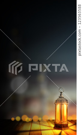 Traditional glowing Arabic lantern with a blurred silhouette of a mosque view on a night scene background. Copy space or mockup. Concept of Eid Al Fitr and Ramadan Mubarak. Ramadan kareem background 123563588