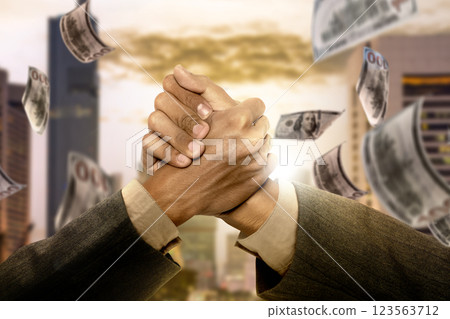 Business handshake together with dollar bills falling from the sky. Concept of business, finance, and economy 123563712