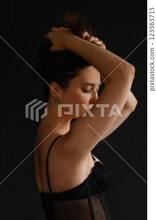 Elegant young woman in a black corset top and gray trousers Elegant young woman in a black corset top and gray trousers 123563715