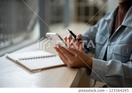 Close up of a person looking at the smartphone holding in left hand with right hand typing. Close up of a person looking at the smartphone holding in left hand with right hand typing. 123564265