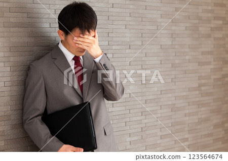 一位身穿灰色西裝、憂心忡忡的中年男性商人 123564674