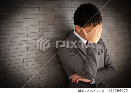 一位身穿灰色西裝、憂心忡忡的中年男性商人 一位身穿灰色西裝、憂心忡忡的中年男性商人 123564675