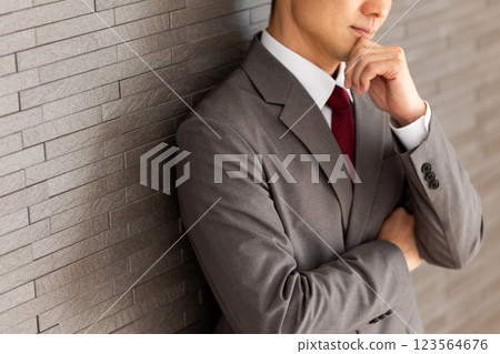 一位身穿灰色西裝的中年男性商人思考 123564676