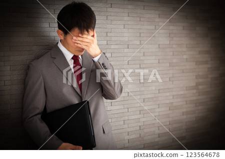 A middle-aged male businessman wearing a gray suit and worried 123564678