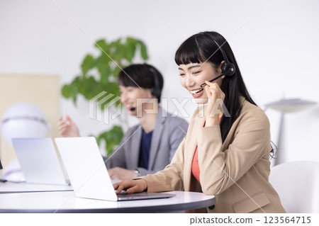 Young men and women working in a business call center 123564715