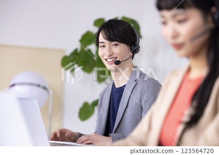 Young men and women working in a business call center 123564720