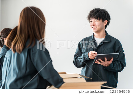 A worker of a transportation, logistics, courier, distribution, delivery, or delivery company packing packages into cardboard boxes A worker of a transportation, logistics, courier, distribution, delivery, or delivery company packing packages into cardboard boxes 123564966